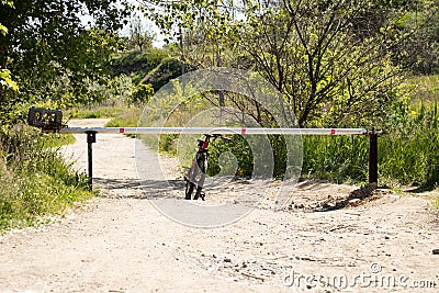 The bicycle is standing near the barrier on the road, the passage is closed, the road is blocked, a bike ride in the summer Stock Photo