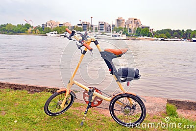 Bicycle Strida on coast of river. Editorial Stock Photo