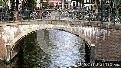 Bicycles chained to a bridge over a canal in amsterdam Stock Photo