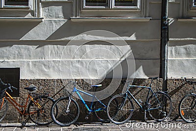 bicycles parked along a wall, raking light Stock Photo