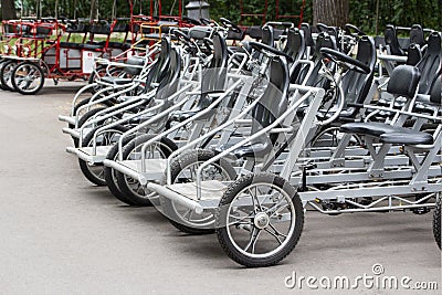 Bicycles for rent steel black pedal. Parked rental tourist trike vehicles velomobiles. Ecological urban transport Stock Photo