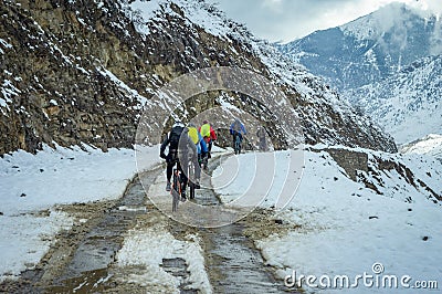 Bicyclists Biking on Snowy Road Stock Photo