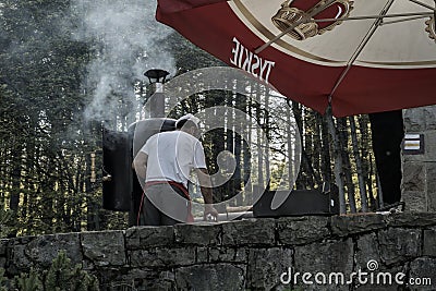 Bielsko Biala, South Poland: A chef preparing barbecue famous grilled cheese made of sheep milk on the mountain Editorial Stock Photo