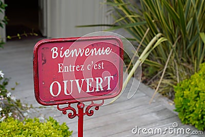 Bienvenue entrez c`est ouvert means in french welcome come in it`s open boutique sign board on store entrance shop Stock Photo