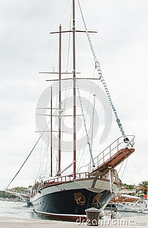 Big beautiful wooden yacht with sails moored to the shores of Cr Editorial Stock Photo