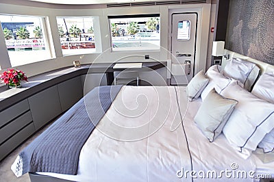 Big bed inside boat with pillows and three windows and small door Stock Photo