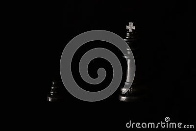 Big chess king and a small pawn on a dark background Stock Photo