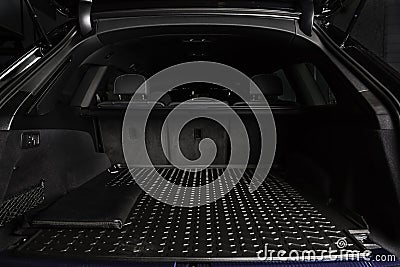 The big black empty trunk of SUV car with rubber mat and with leather folder on the floor Open luggage carrier of car closeup Stock Photo