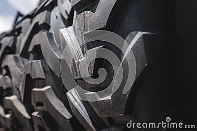 Big black huge big truck, tractor or bulldozer loader tires wheel close-up on stand, shop selling tyres for farming and big vehicl Stock Photo