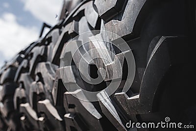 Big black huge big truck, tractor or bulldozer loader tires wheel close-up on stand, shop selling tyres for farming and big vehicl Stock Photo