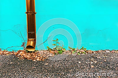A big blue color water supply main pipeline with a stopcock valve against a yellow concrete wall Stock Photo