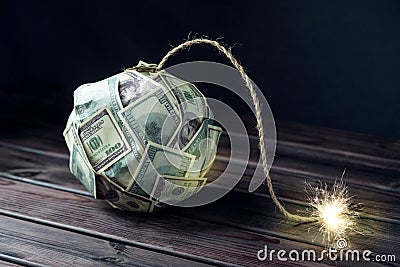 Bomb of money hundred dollar bills with a burning wick. Little time before the explosion. Concept of financial crisis Stock Photo