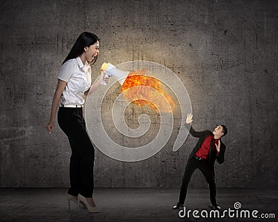 Big boss yelling to her employee with megaphone on fire Stock Photo