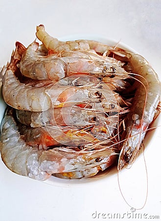 A big bowl of neatly arranged raw shrimps Stock Photo