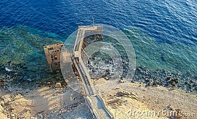 Antique iron and wooden pier in front of the lighthouse on Big Brother Island, Red Sea Editorial Stock Photo