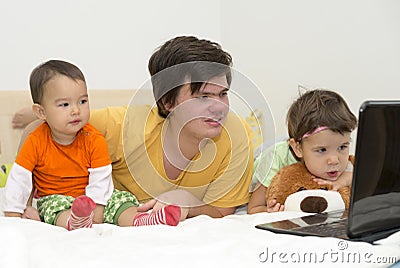 Big brother watching cartoons with his younger sisters at laptop Stock Photo