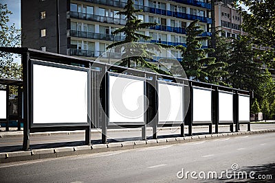 Big bus stop in a modern city with blank advertising banners inside Stock Photo