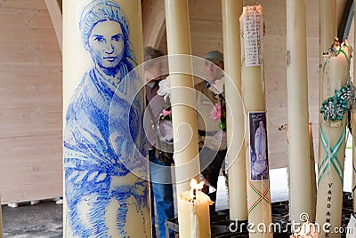 Big candles with images of Saint Bernadette at the praying site of Sanctuary. Place for catholic Editorial Stock Photo