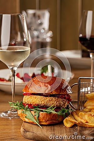 Big cheeseburger with french fries. Hamburger with beef patty onion, tomato, lettuce pickles, melted cheddar, mustards Stock Photo