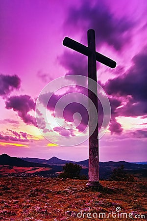 Big Christian cross standing on top of a hill Radobyl in CHKO Ceske Stredohori area at evening after sunset in czech summer land Stock Photo
