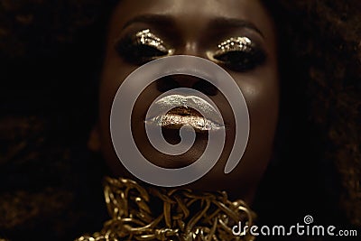 Big close-up surreal portrait of majestic african american female model with gold glossy makeup. Fashion Vogue concept Stock Photo