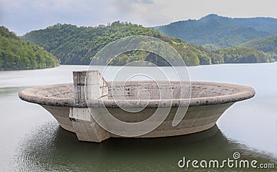 Big concrete overflow funnel above the lake. Stock Photo