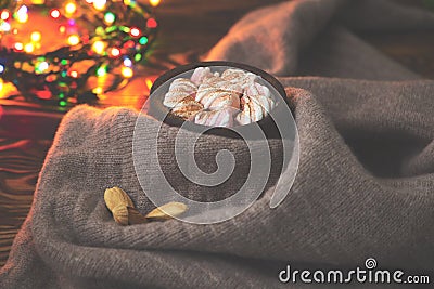 Big cup of hot cocoa with marshmallow, cinnamon and nurs and warm blanket on an old vintage wooden and Christmas light. Cozy chris Stock Photo