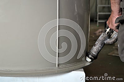 Big cylindrical custom made plastic tank in the process of polishing Stock Photo