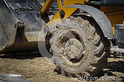 Big dirty wheel of a heavy industrial truck, bulldozer Stock Photo