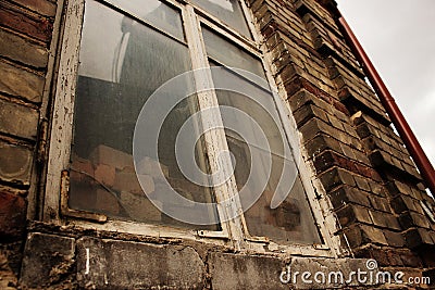 Big dirty window in old dark brick wall Stock Photo