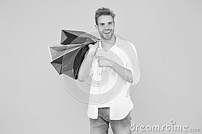 Big discount. Happy man holding purchases in paper bags. If I want I will get. Bachelors day. Consumerism concept Stock Photo