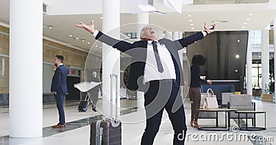 Big effort, big results. 4k video footage of a mature businessman throwing his paperwork in the air after receiving good Stock Photo