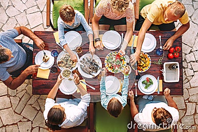 Big family have a dinner with fresh cooked meal on open garden t Stock Photo