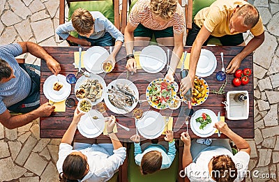 Big family have a dinner with fresh cooked meal on open garden t Stock Photo