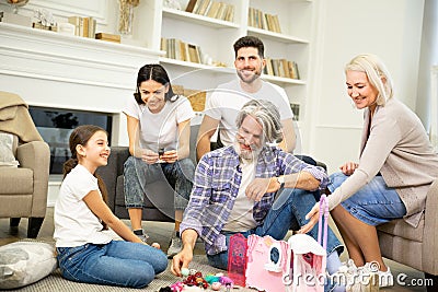 Big family having fun time together playing with child and her dollhouse Stock Photo