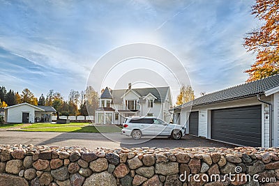 Big family house with double size garage and car parked in front. Residential house with concrete driveway and entrance door under Stock Photo