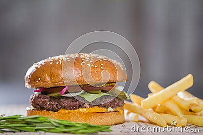 Big fresh appetizing burger with pepper and potatoes Stock Photo