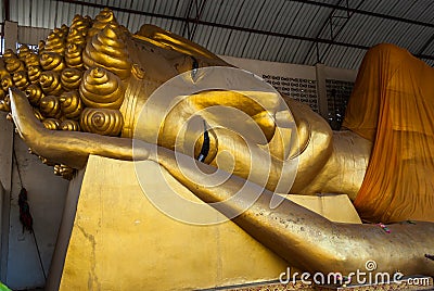 Big golden head of Reclining Buddha Image (Phra Norn) Stock Photo