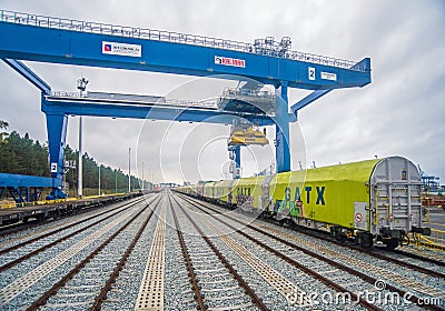 Big modern blue gantry crane and a railroad wagons Editorial Stock Photo