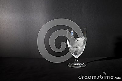 Ice cube melting in wine glass isolated in black background Stock Photo