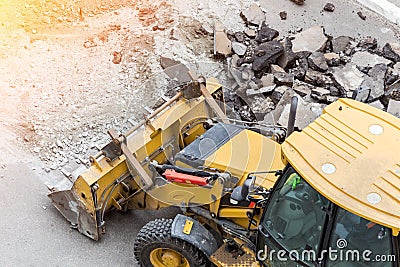 Big jackhammer drill drilling road.Heavy machinery crushing asphalt for stormwater drain repair Stock Photo