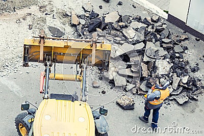 Big jackhammer drill drilling road.Heavy machinery crushing asphalt for stormwater drain repair Stock Photo