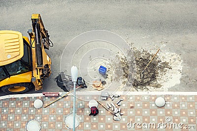 Big jackhammer drill drilling road.Heavy machinery crushing asphalt for stormwater drain repair Stock Photo