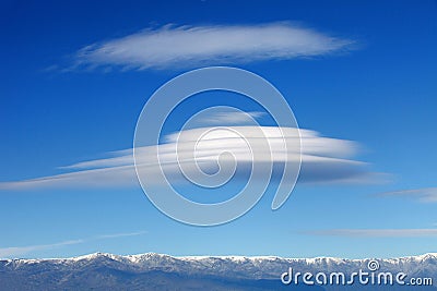 Big lenticularis cloud and snowed mountain Stock Photo