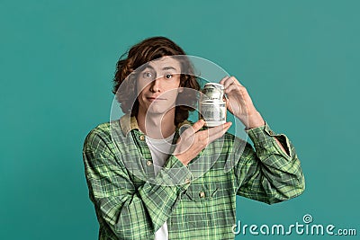 Big luck concept. Rich young guy holding dollars on color background Stock Photo