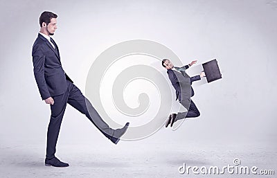 Big man kicking little himself out Stock Photo