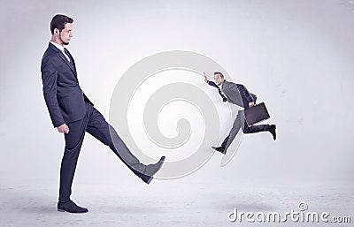 Big man kicking little himself out Stock Photo