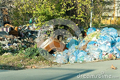 Big metal dumpster garbage cans full of overflow litter polluting the street in the city, environmental concept Stock Photo