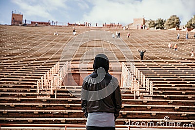 Symmetrical Portrait of Male Person Standing Front and Center on a Stage Dreaming and Imagining the Future while Facing Stadium St Stock Photo