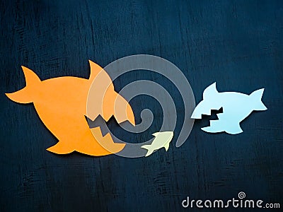 Big paper fish and small one. Merger and acquisition. Stock Photo